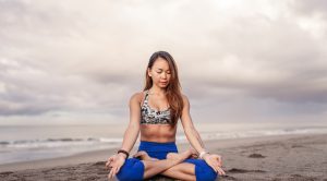 female doing yoga on beach