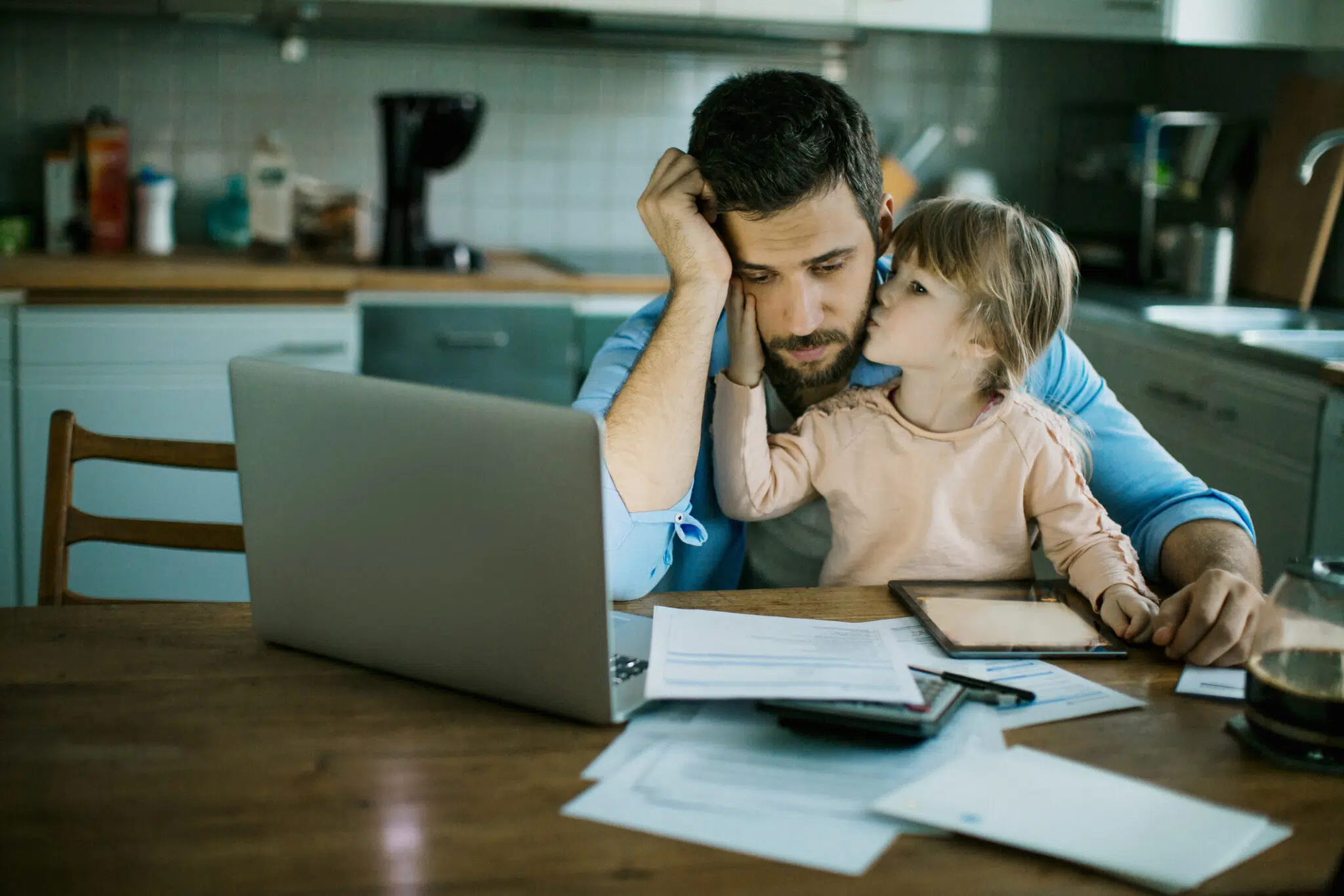 Father reviewing changes to income protection insurance policy on laptop with daughter