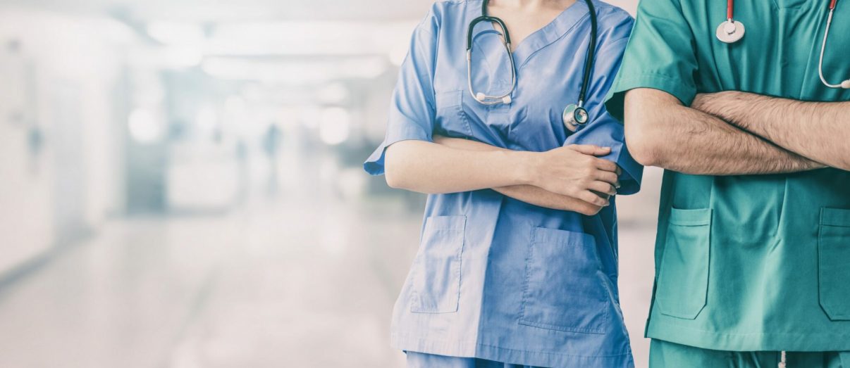 Two hospital staffs - surgeon, doctor or nurse standing with arms crossed in the hospital. Medical healthcare and doctor service.