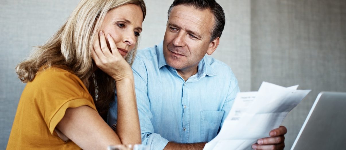 Couple reviewing income protection changes on laptop