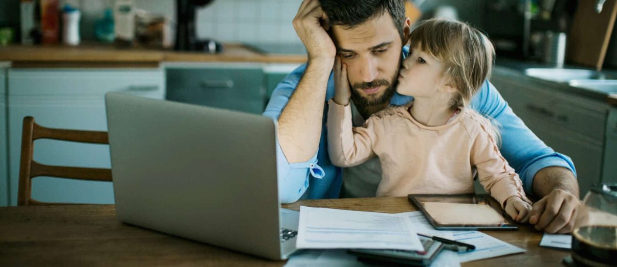 Father reviewing changes to income protection insurance policy on laptop with daughter