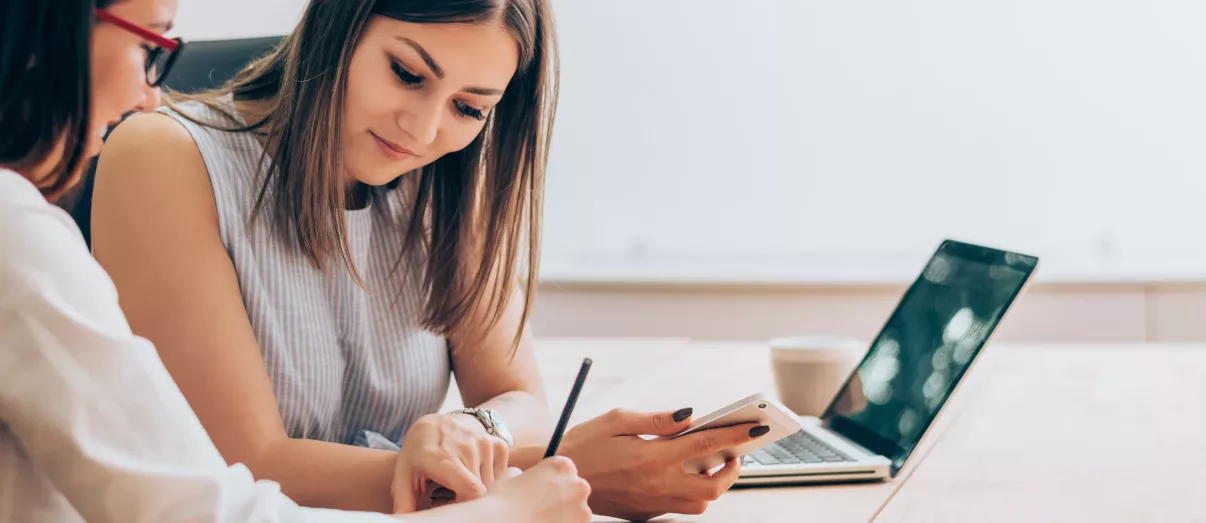 Two female colleagues in office working together.