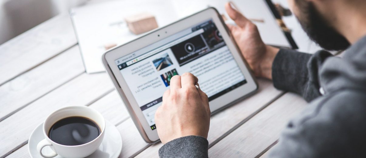 Media Library 1 man-scrolling-through-ipad-reading-news
